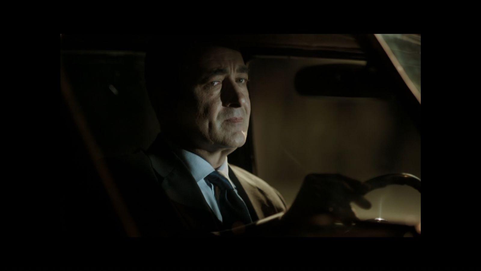 Ben Onu Çok Sevdim — A suited man seated inside a car at night.