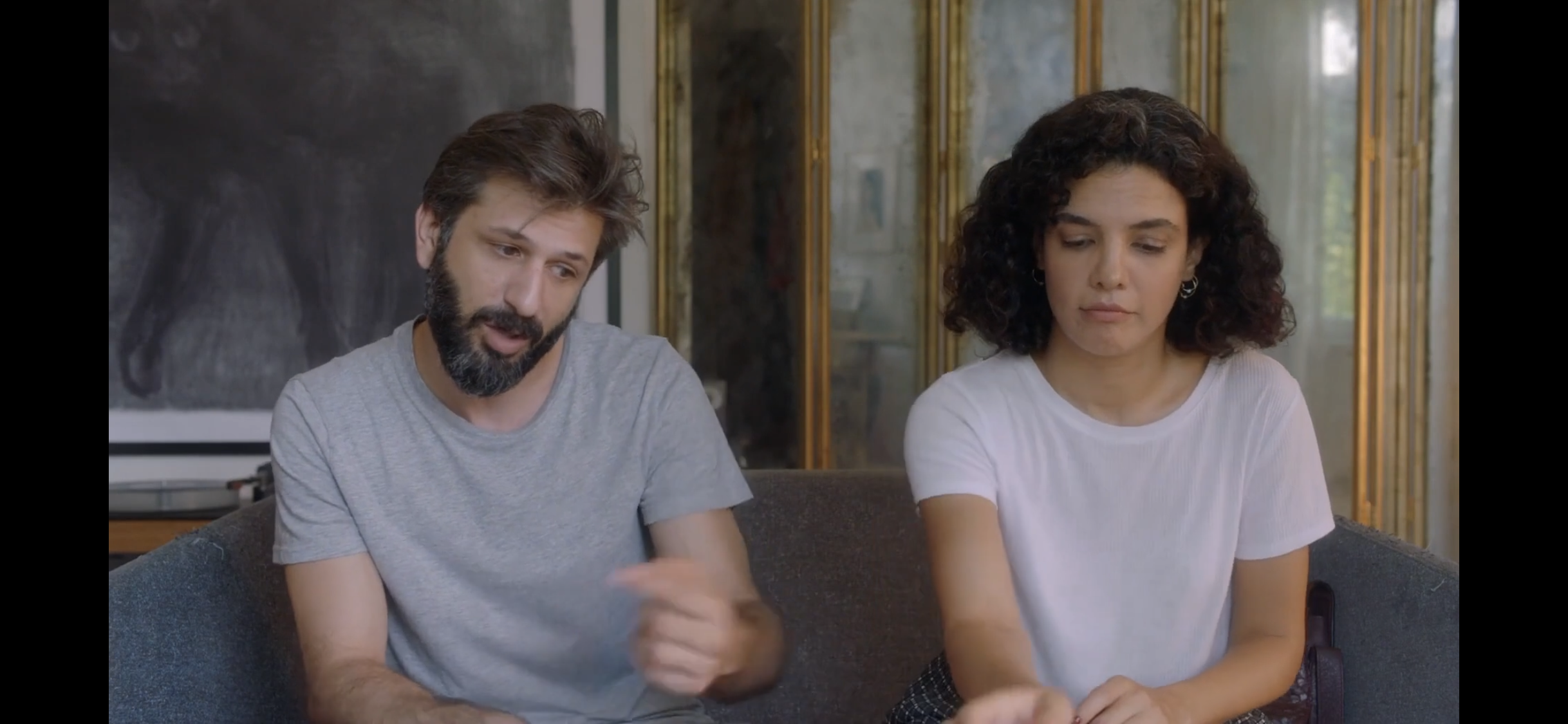 Diyalog — A man and a woman sitting side by side on a sofa in daylight.