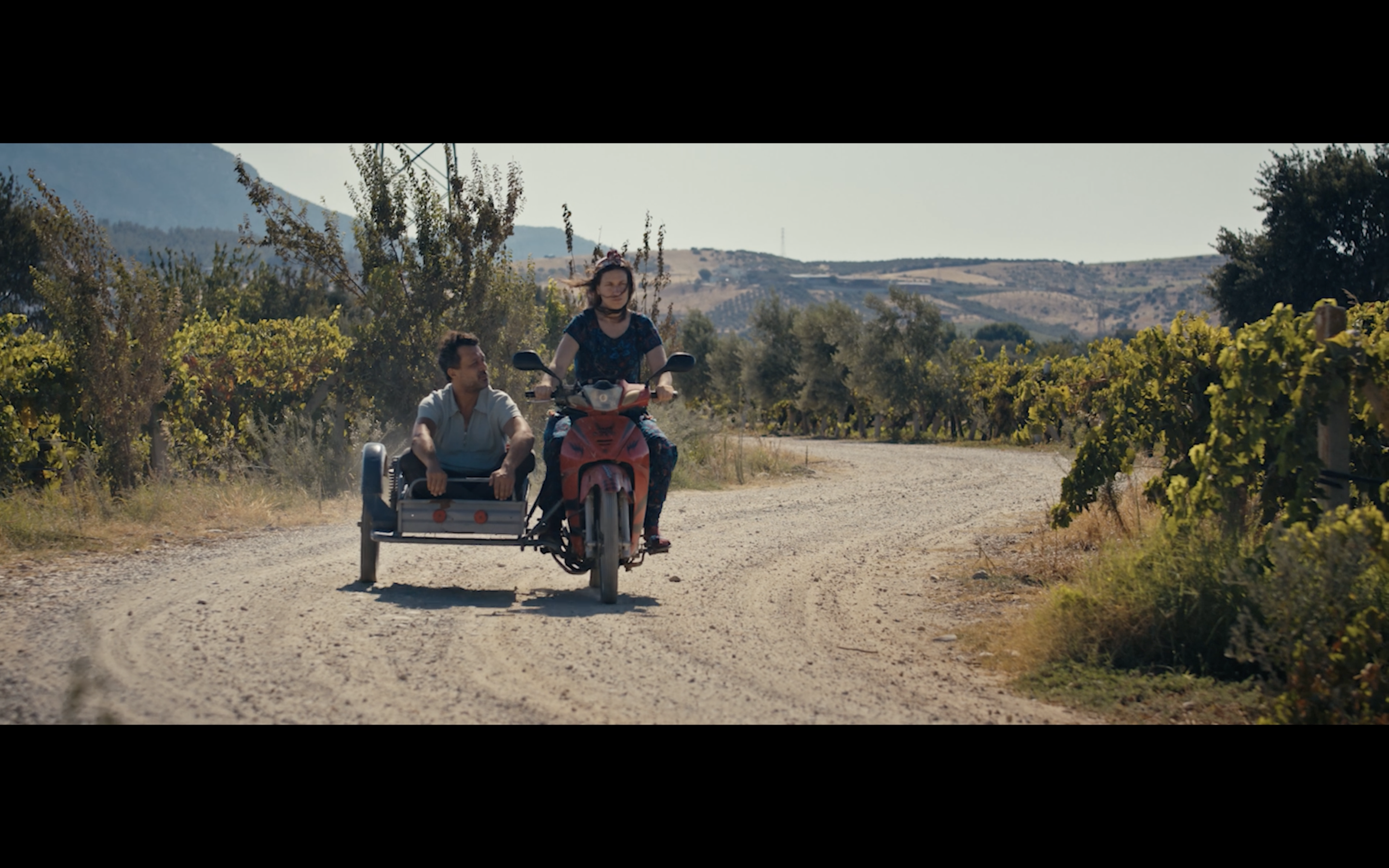 Kavanoz — Two men riding a motorcycle and sidecar along a country road.