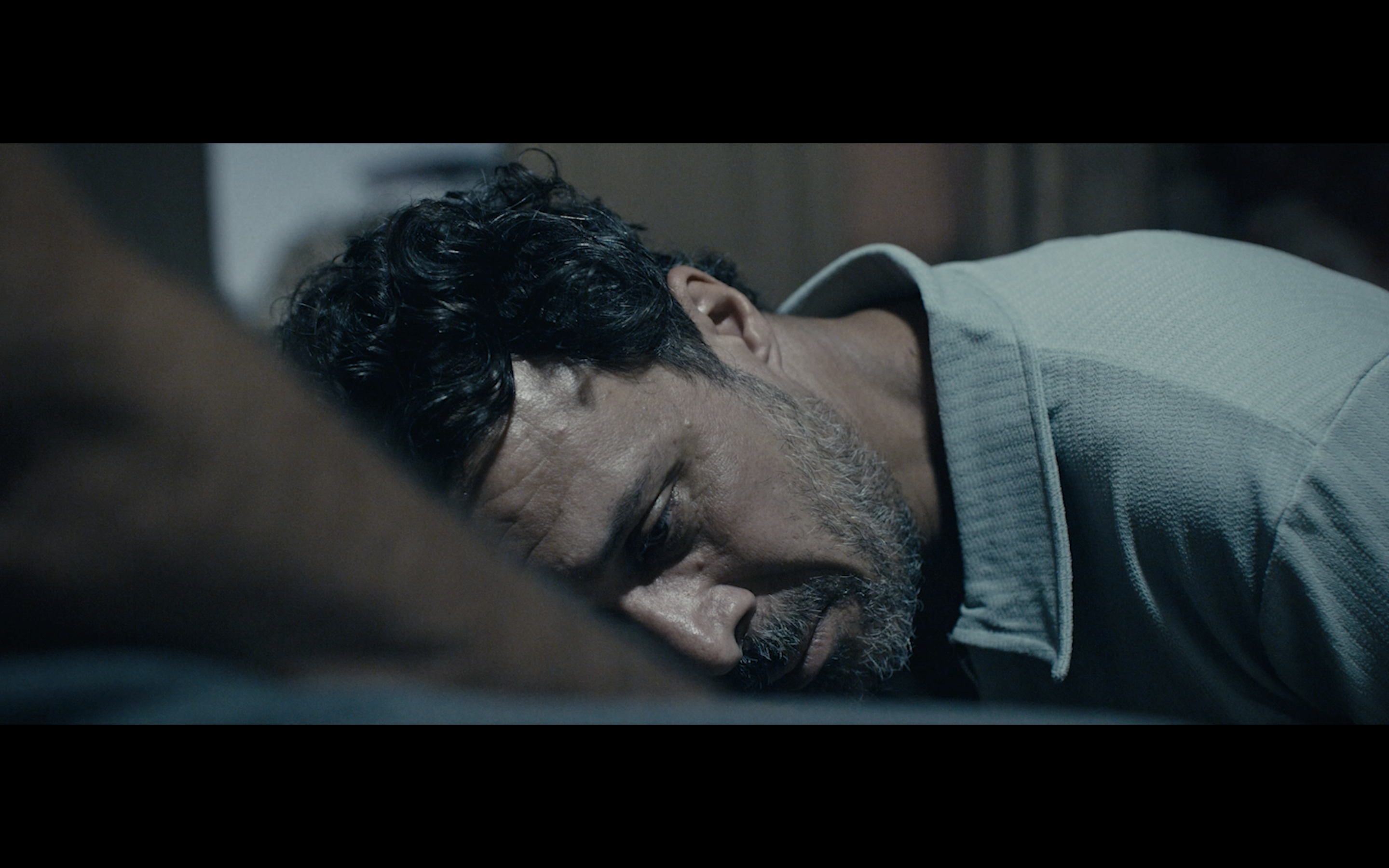 Kavanoz — Close-up of a man resting his head on his arm.