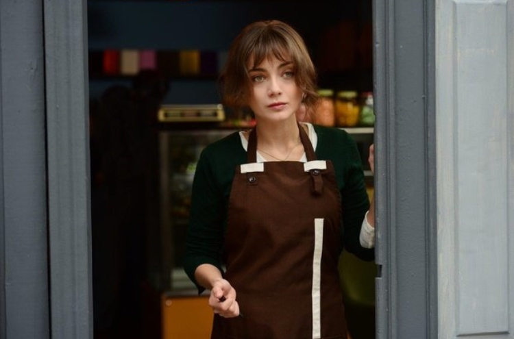 Masum Değiliz — A woman in a brown apron standing in a doorway.