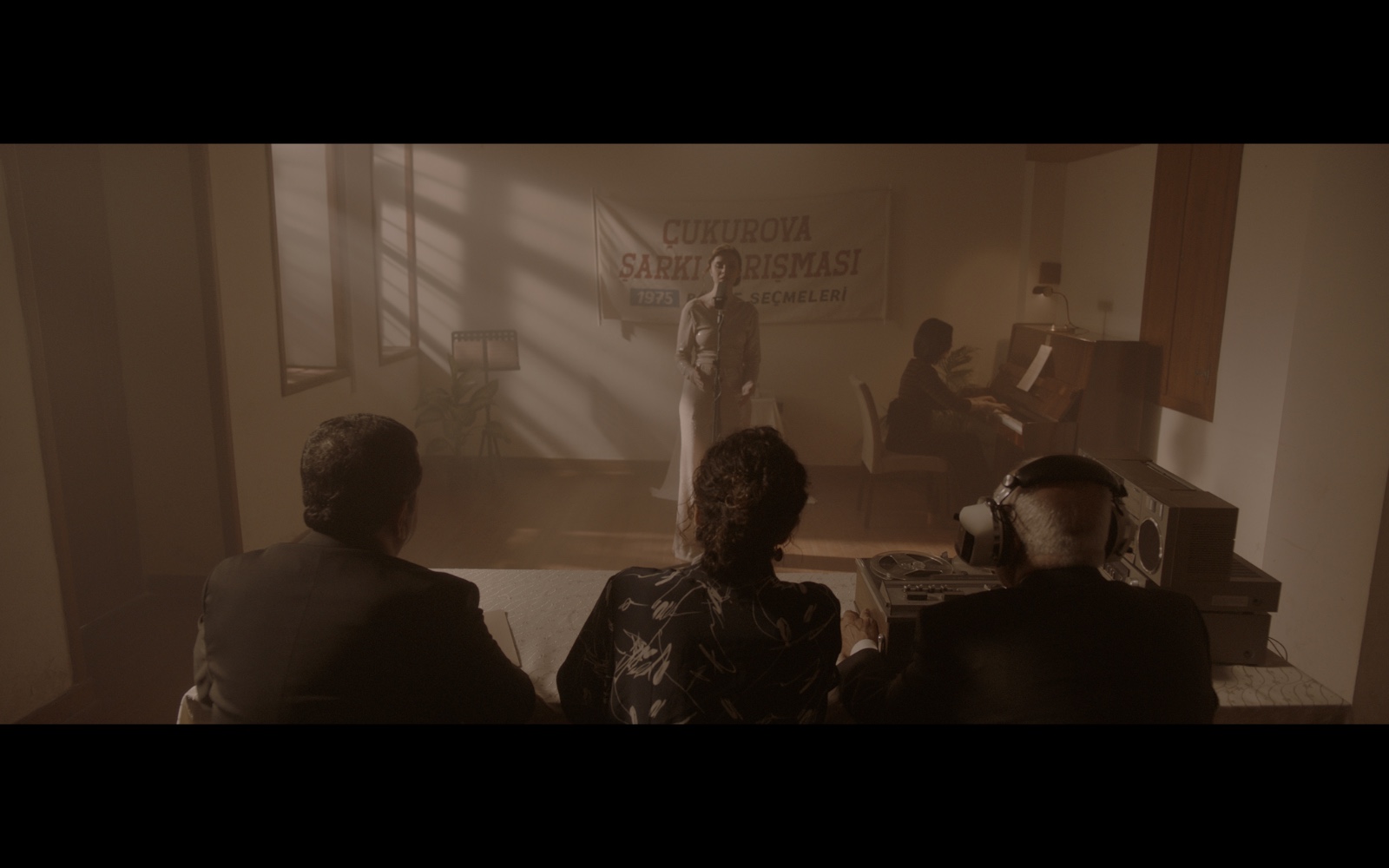 Radyo Günleri — An audience watching a singer in a room filled with warm window light.