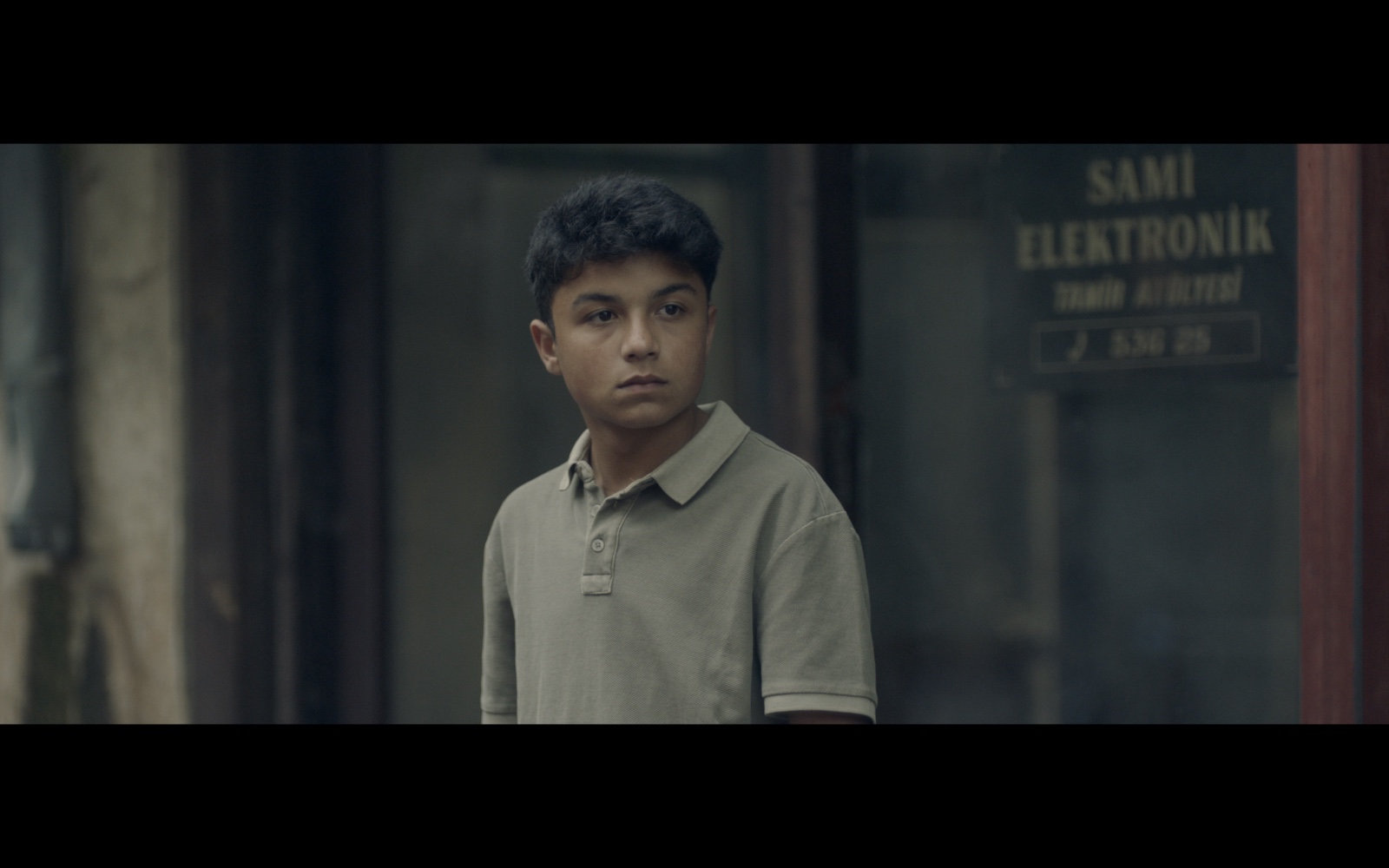 Radyo Günleri — A boy standing outside an electronics shop.