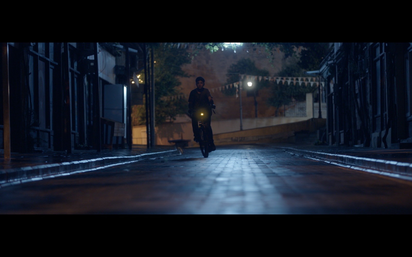 Radyo Günleri — A lone figure in a blue-lit street at night.