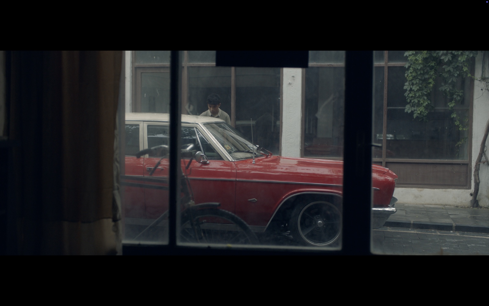 Radyo Günleri — A red car seen through a shop window.