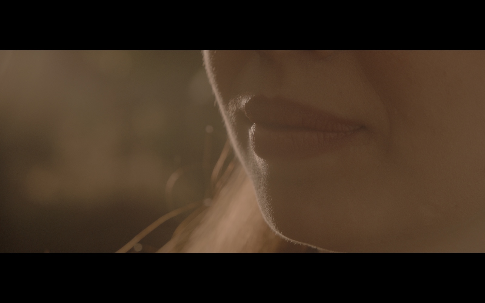 Radyo Günleri — Close-up of a woman’s lips in warm light.